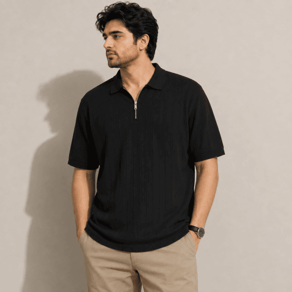 Half zip Black polo model Man wearing a black half zip polo shirt in textured drop needle knit with beige chinos