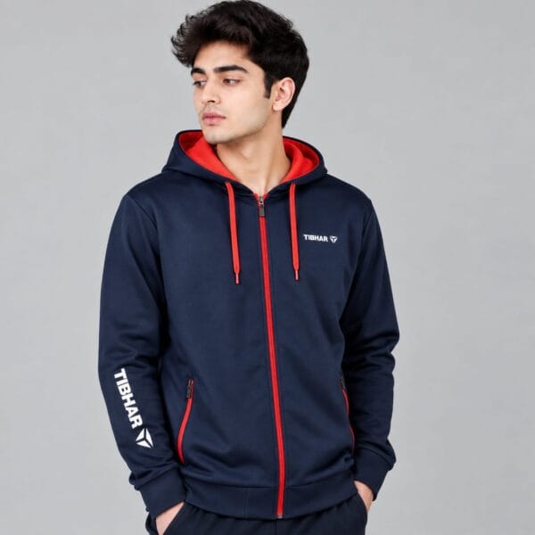 Tibhar hooded training jacket in navy with red lined hood, red drawcords and full zip, worn by model