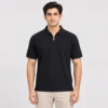 Man wearing a Sportlux Plus black quarter zip polo in fine cotton pique, front view, silver metal zip and tonal black embroidered S on the left chest