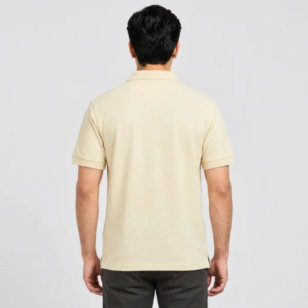 Back view of the Sportlux Plus cream quarter zip polo on a model, level hem covering the waistband, ribbed sleeve bands and side vents
