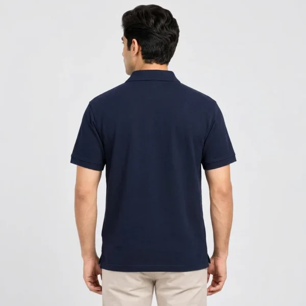 Back view of a man wearing the Sportlux Plus navy quarter zip polo, plain back, ribbed sleeve bands and side vents at the hem