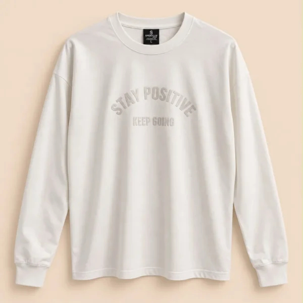 Sportlux Plus off-white oversized full sleeve t-shirt with tonal STAY POSITIVE KEEP GOING chest print, drop shoulder, rib collar and cuffs, flat lay